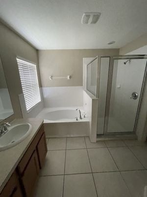 Empty bathroom after move-out clean — tub, shower, vanity